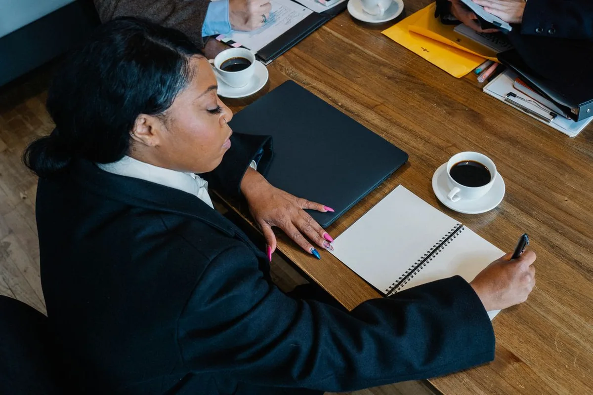 Profesional tomando notas en una reunión — imagen ilustrativa