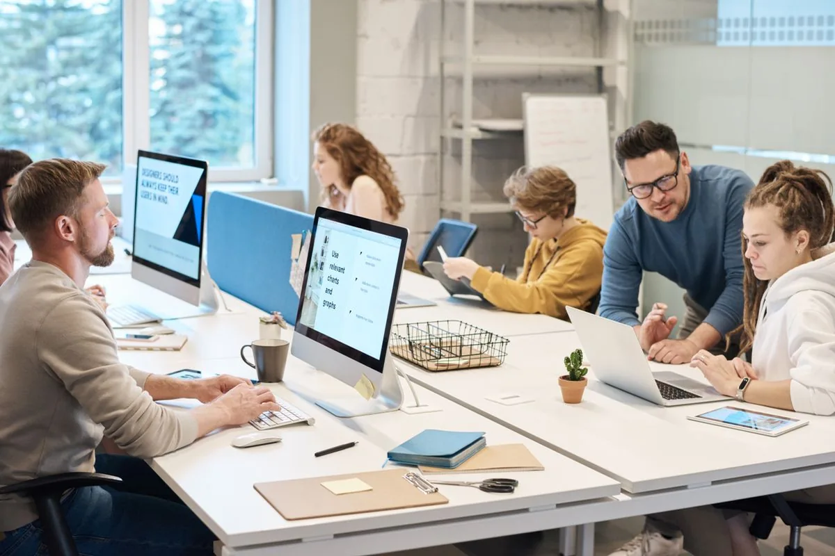 Equipo trabajando con computadoras y documentos — imagen ilustrativa