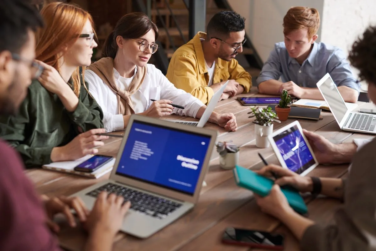 Equipo reunido para revisar información en computadoras — imagen ilustrativa