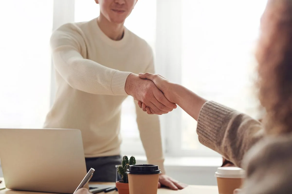 Saludo entre profesionales durante una reunión — imagen ilustrativa